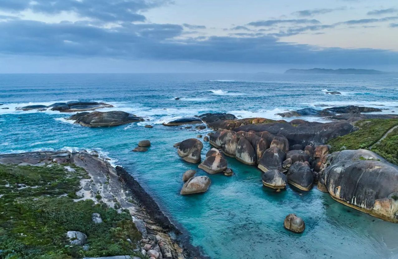 Elephant Rocks, rounded granite in a turquoise channel under a heavy sky.