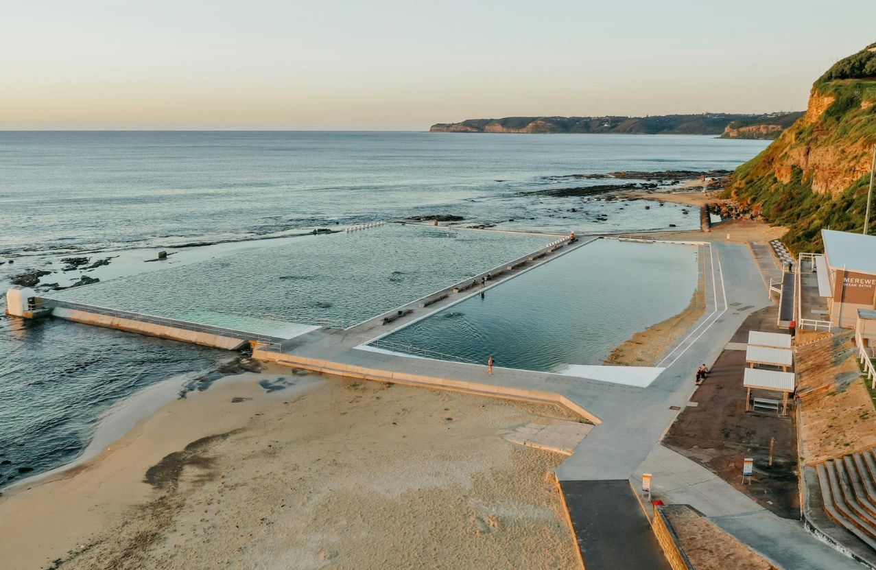 Merewether ocean baths at golden hour, two saltwater pools set into the rock platform.