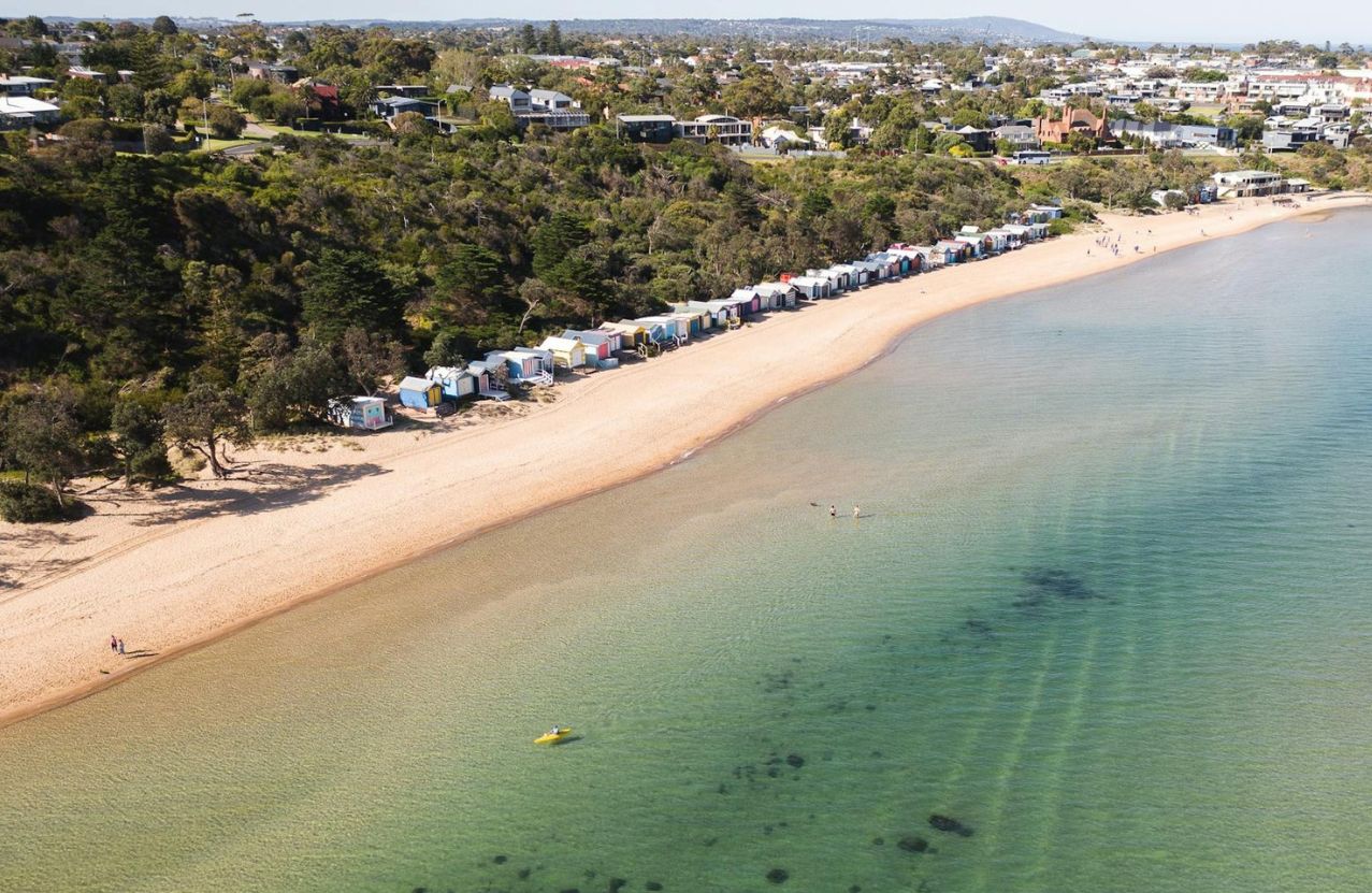 Mills Beach, Mornington, a row of coloured bathing boxes along the sand.