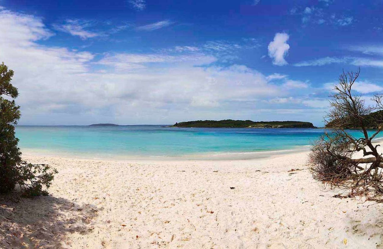 Murrays Beach in Jervis Bay, a ribbon of white sand and pale turquoise water with Bowen Island on the horizon.